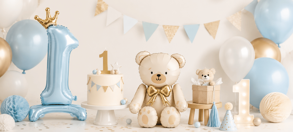 timmungsvolles Banner für den 1. Geburtstag mit Ballons, Teddybär, Geburtstagstorte und Dekoration in sanften Blau- und Goldtönen.