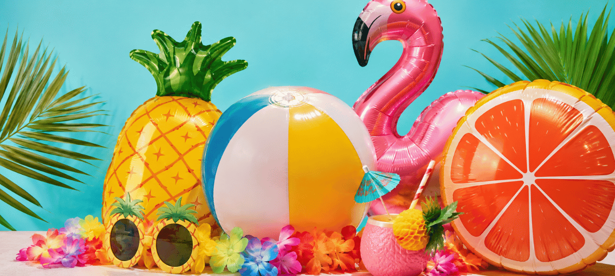 Farbenfrohe Sommerparty mit tropischen Folienballons, Flamingo, Ananas, Strandball und sommerlicher Partydekoration.